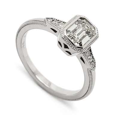 14kt white gold engagement ring with emerald cut lab diamond and side diamonds, millgrain detail