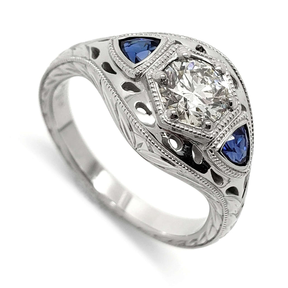 14kt white gold engagement ring with round lab diamond and trillion blue sapphires, engraved and millgrain details