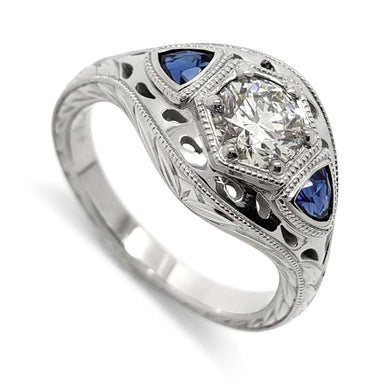 14kt white gold engagement ring with round lab diamond and trillion blue sapphires, engraved and millgrain details