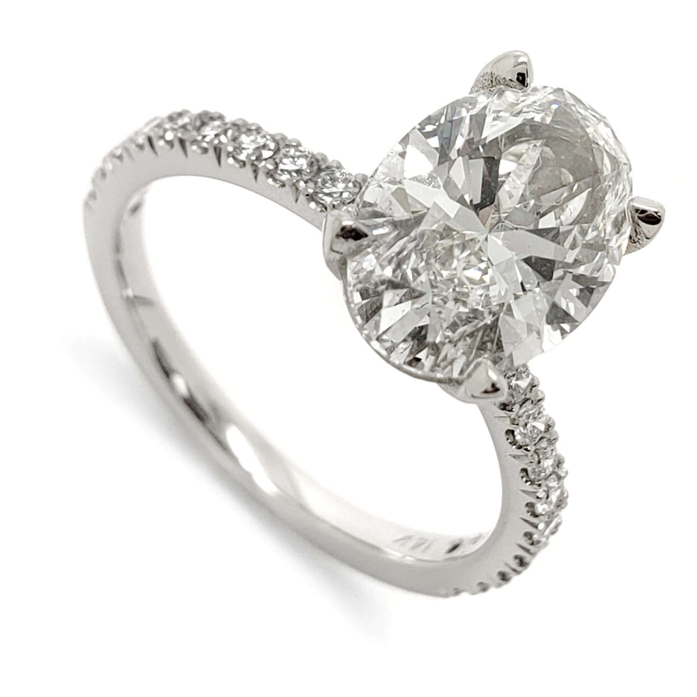 14kt white gold engagement ring with oval lab grown diamond and French pave band