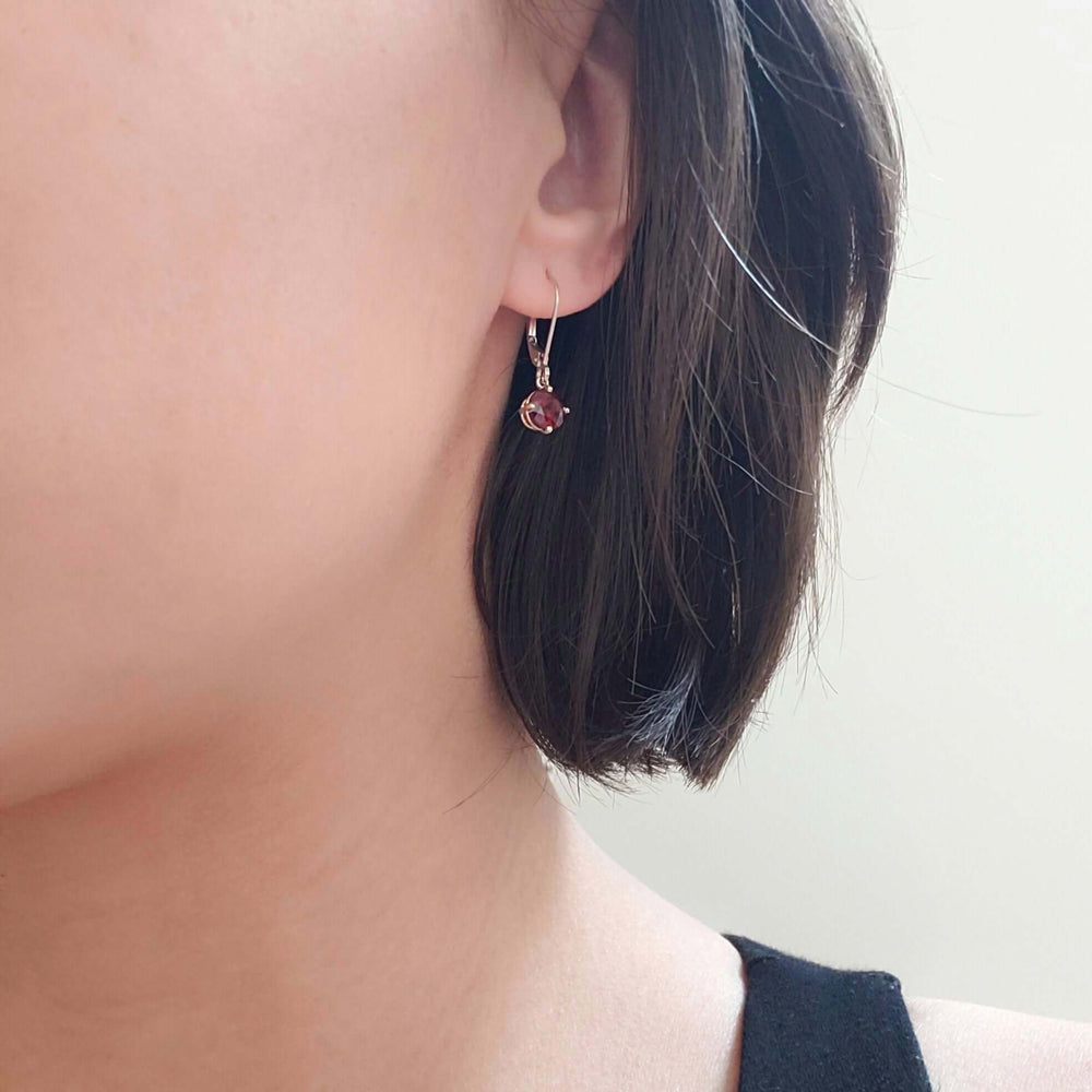 14kt white gold garnet drop earring worn on ear