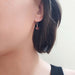 14kt white gold garnet drop earring worn on ear