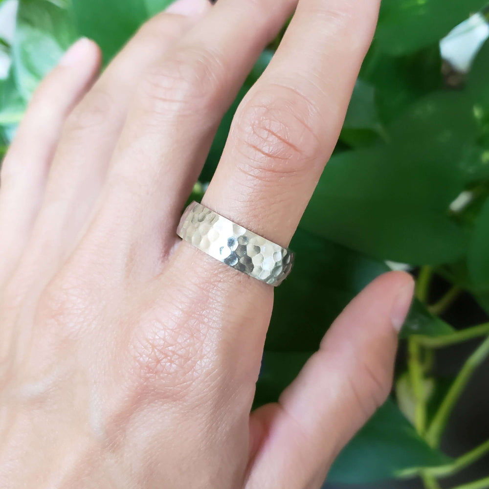 14kt white gold hammered wedding ring worn on a hand