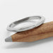 14kt white gold knife edge wedding ring with millgrain, resting on a pencil