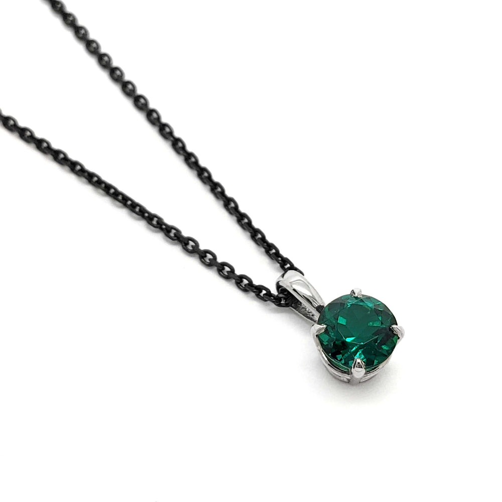 14kt white gold pendant with round lab-grown emerald on a dark chain