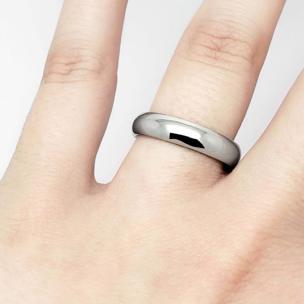 14kt white gold low dome wedding ring worn on a hand