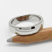14kt white gold millgrain wedding ring resting on a pencil