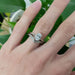 14kt white gold oval lab diamond engagement ring paired with engraved wedding band on hand