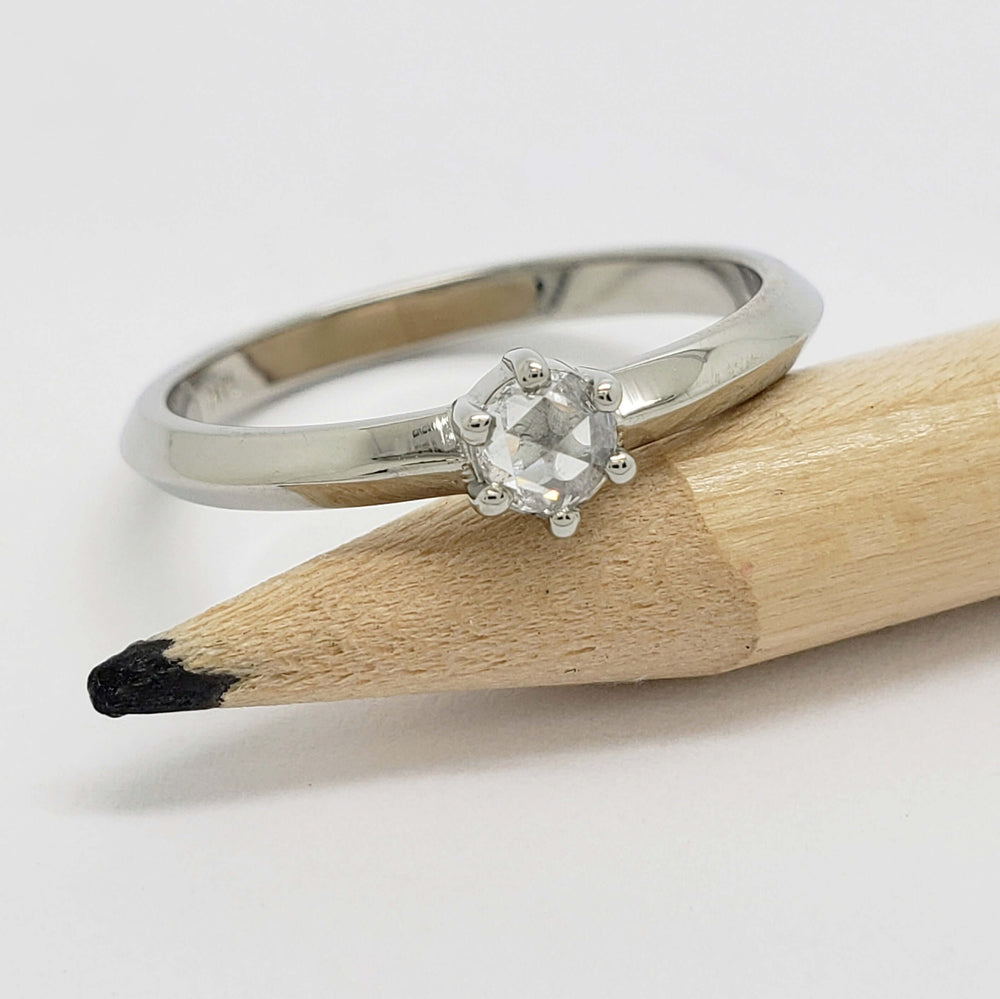 14kt white gold rose cut diamond ring resting on a pencil