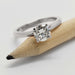 14kt white gold solitaire engagement ring with lab-grown diamond resting on a pencil