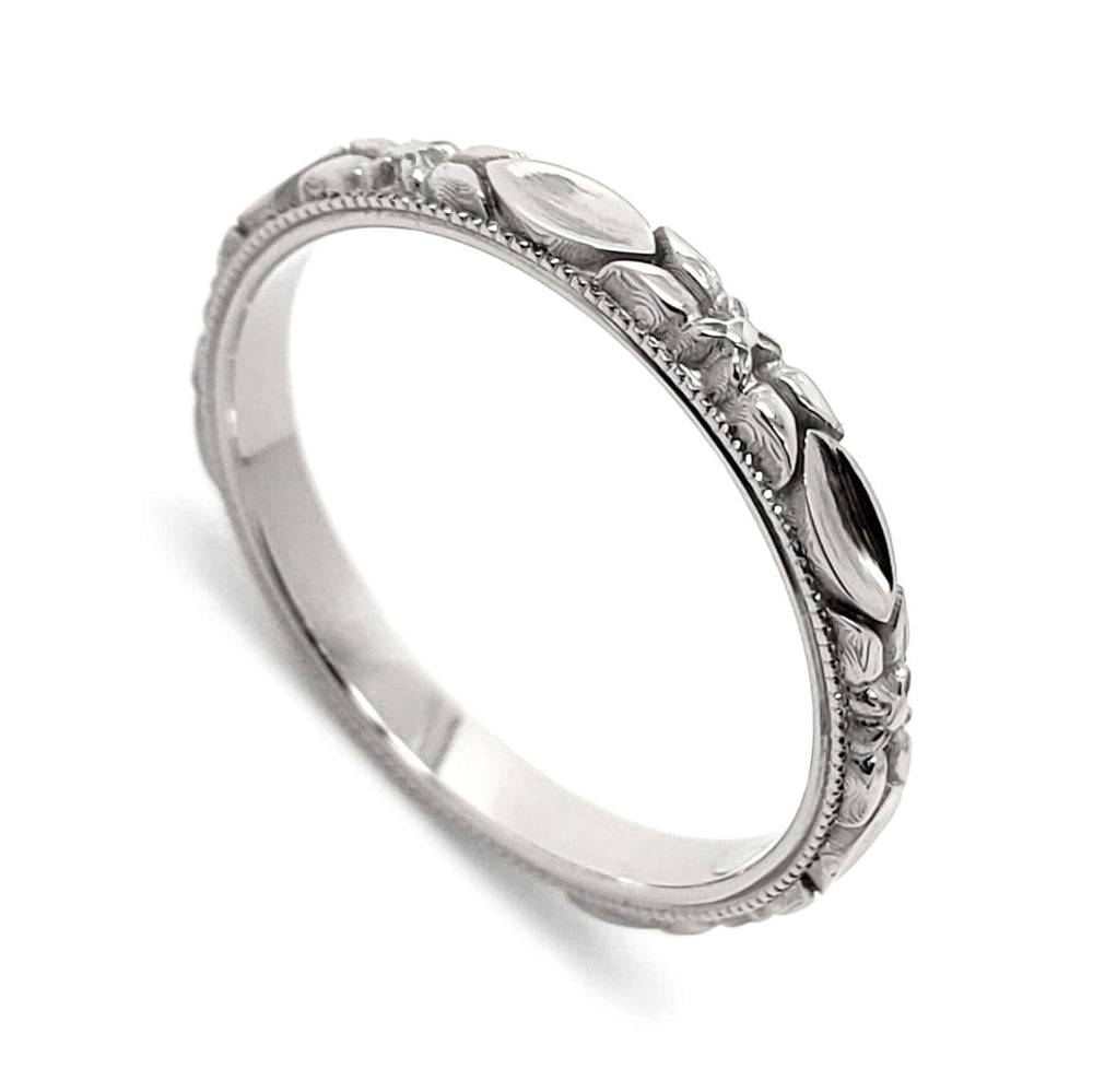 14kt white gold wedding ring with raised leaf and flower details, millgrain edge