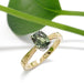 14kt yellow and white gold engagement ring with green sapphire, shown with leaf background