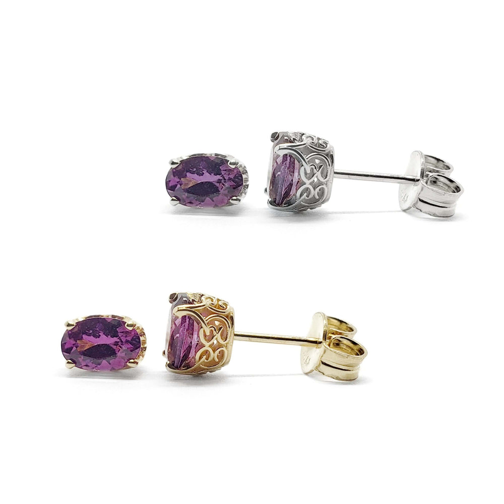 Pair of oval violet garnet stud earrings in 14kt yellow and white gold with scroll settings