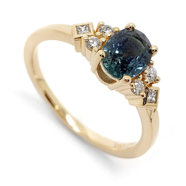 14kt yellow gold ring with oval teal Montana sapphire and round and princess cut diamonds