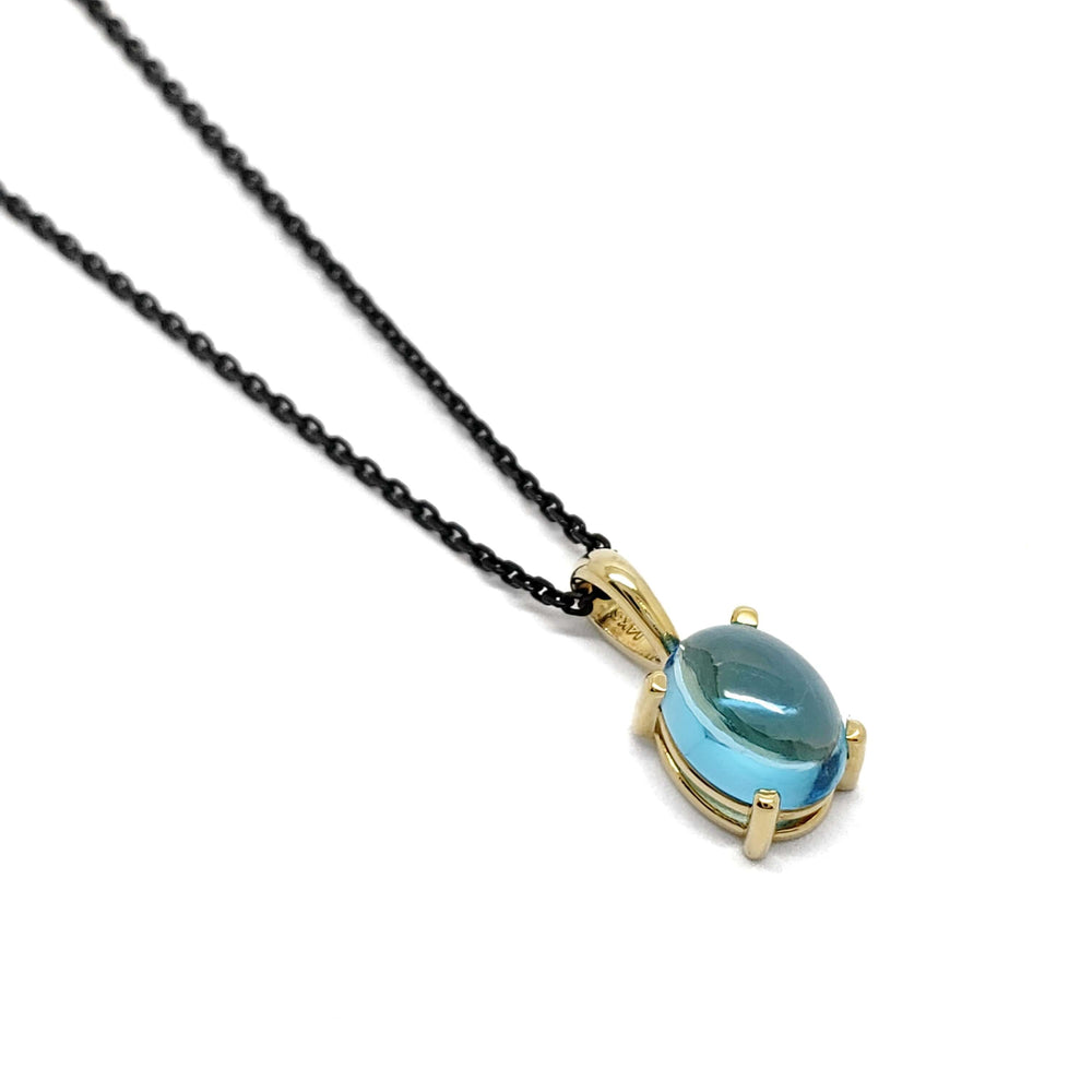 14kt yellow gold pendant with oval cabochon Swiss blue topaz on a black chain