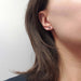 Baguette blue sapphire stud earring in 14kt yellow gold worn on an ear