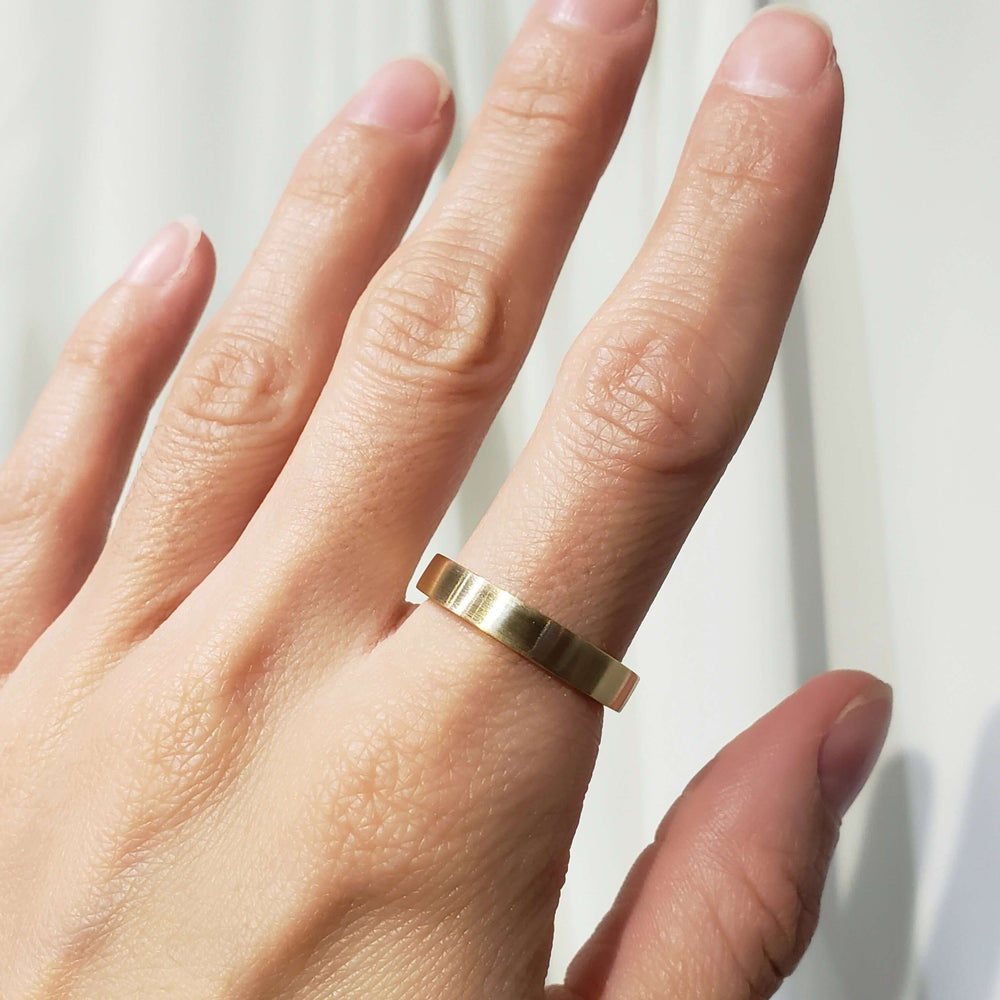 14kt yellow gold brushed wedding band shown on hand, flat profile