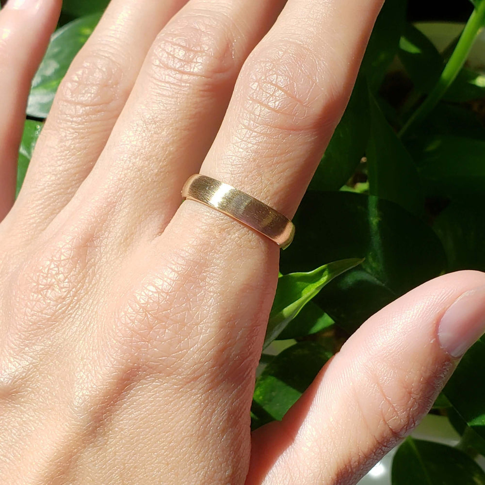 14kt yellow gold brushed wedding ring shown on a hand