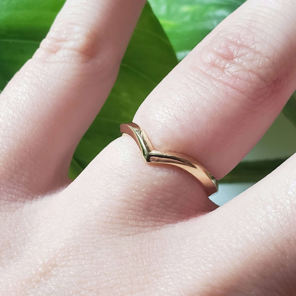 14kt yellow gold chevron wedding ring worn on a finger