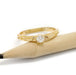 14kt yellow gold diamond engagement ring with engraved details beside a pencil