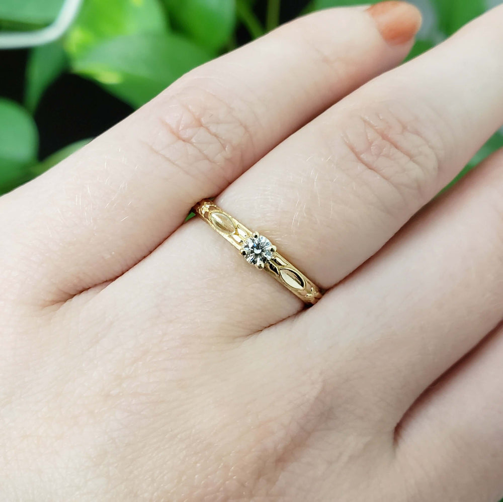 14kt yellow gold diamond engagement ring with leaf details shown on a hand