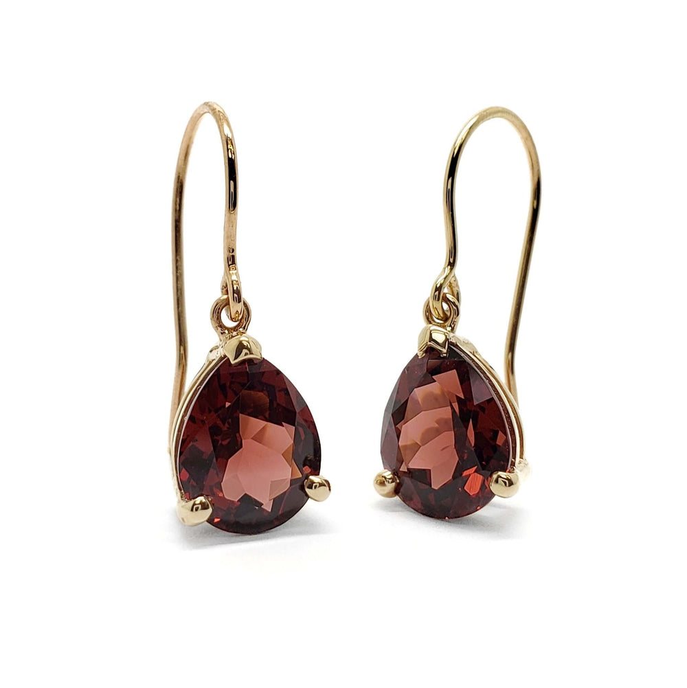 Pair of pear-cut red garnet drop earrings in 14kt yellow gold on white background