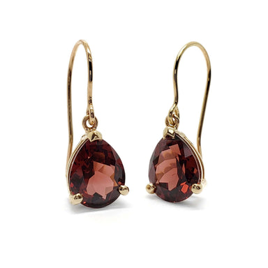 Pair of pear-cut red garnet drop earrings in 14kt yellow gold on white background