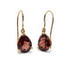 Pair of pear-cut red garnet drop earrings in 14kt yellow gold on white background