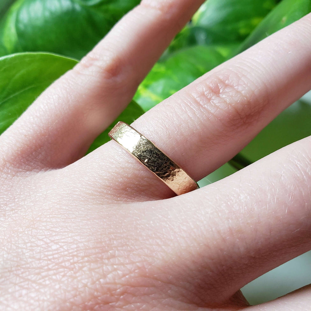 14kt yellow gold elephant skin texture wedding ring worn on a hand
