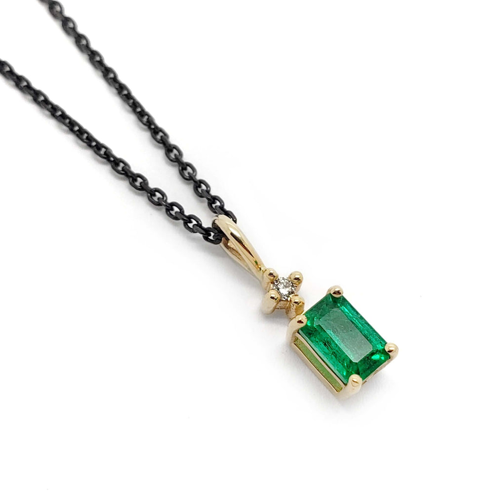 14kt yellow gold pendant with emerald-cut green emerald and diamond on black chain