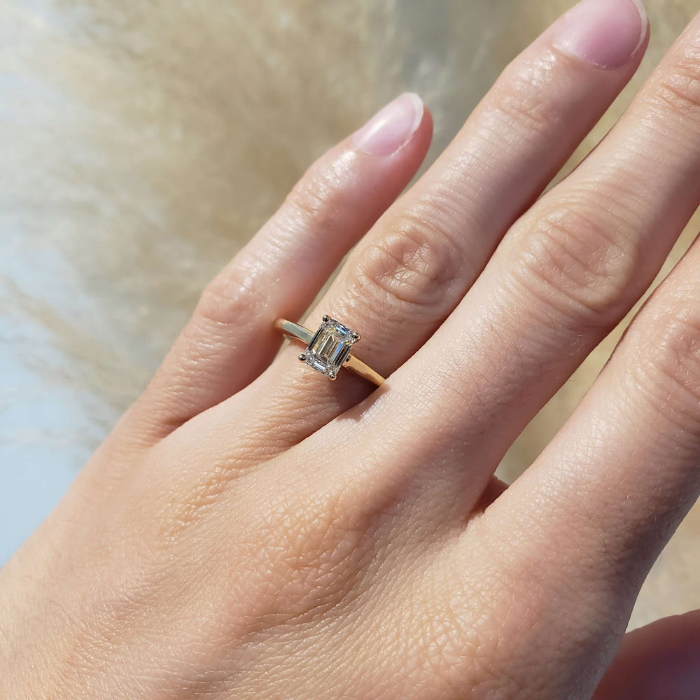 Emerald cut lab diamond ring in 14kt yellow gold shown on hand