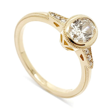 14kt yellow gold engagement ring with bezel-set oval lab diamond and pave shoulders