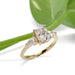 14kt yellow gold engagement ring with cushion and pear cut lab diamonds, shown with green leaf