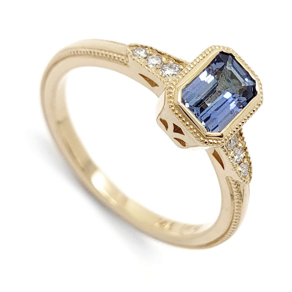 14kt yellow gold engagement ring with emerald cut blue sapphire and diamond accents