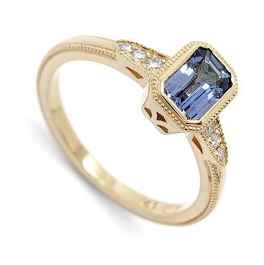 14kt yellow gold engagement ring with emerald cut blue sapphire and diamond accents