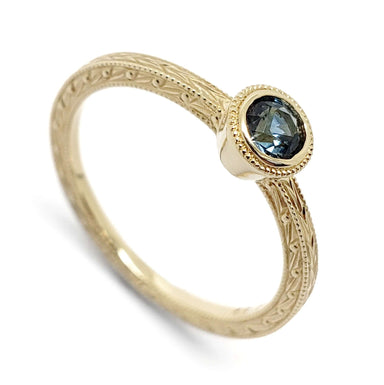 14kt yellow gold engagement ring with teal Montana sapphire and hand engraving