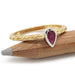 14kt yellow gold engraved ring with pear ruby in white gold bezel, shown on pencil