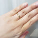 14kt yellow gold engraved wedding ring with millgrain detail shown on a hand