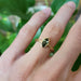 14kt yellow gold green sapphire ring with vintage engraving shown on hand