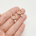 Hand holding 14kt yellow gold hoop earrings with detachable white vintage pearls