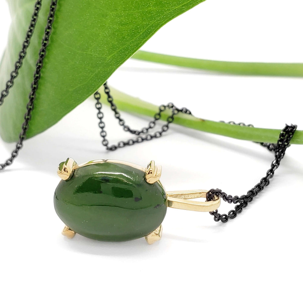 Side view of 14kt yellow gold jade pendant with green leaf and dark chain
