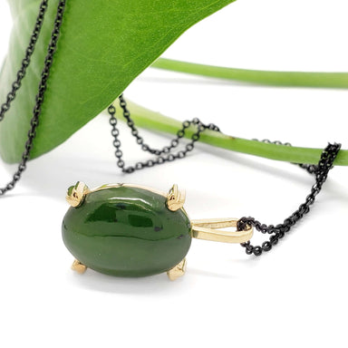 Side view of 14kt yellow gold jade pendant with green leaf and dark chain