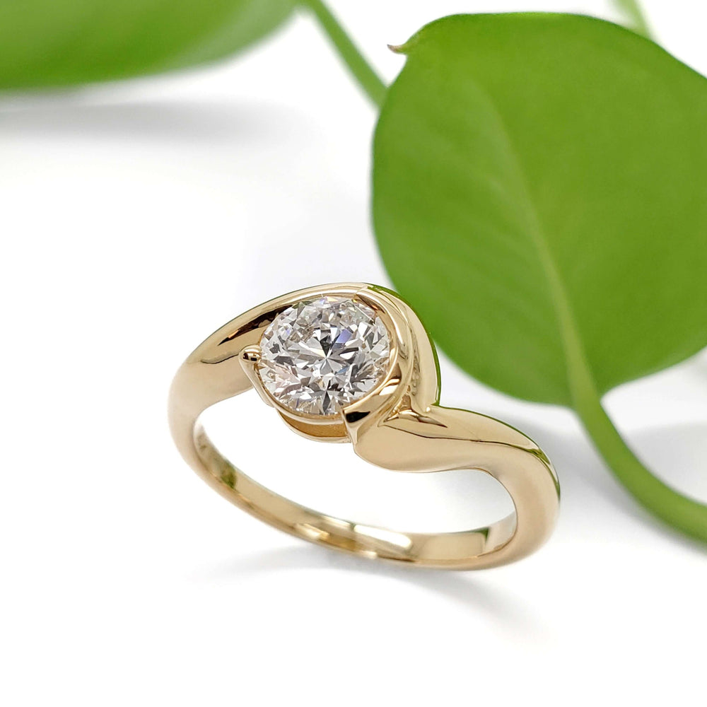 14kt yellow gold lab diamond ring with curved band, shown with green leaf background