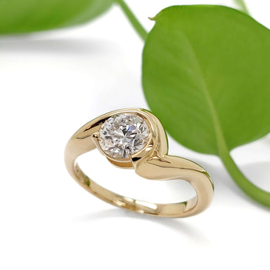 14kt yellow gold lab diamond ring with curved band, shown with green leaf background