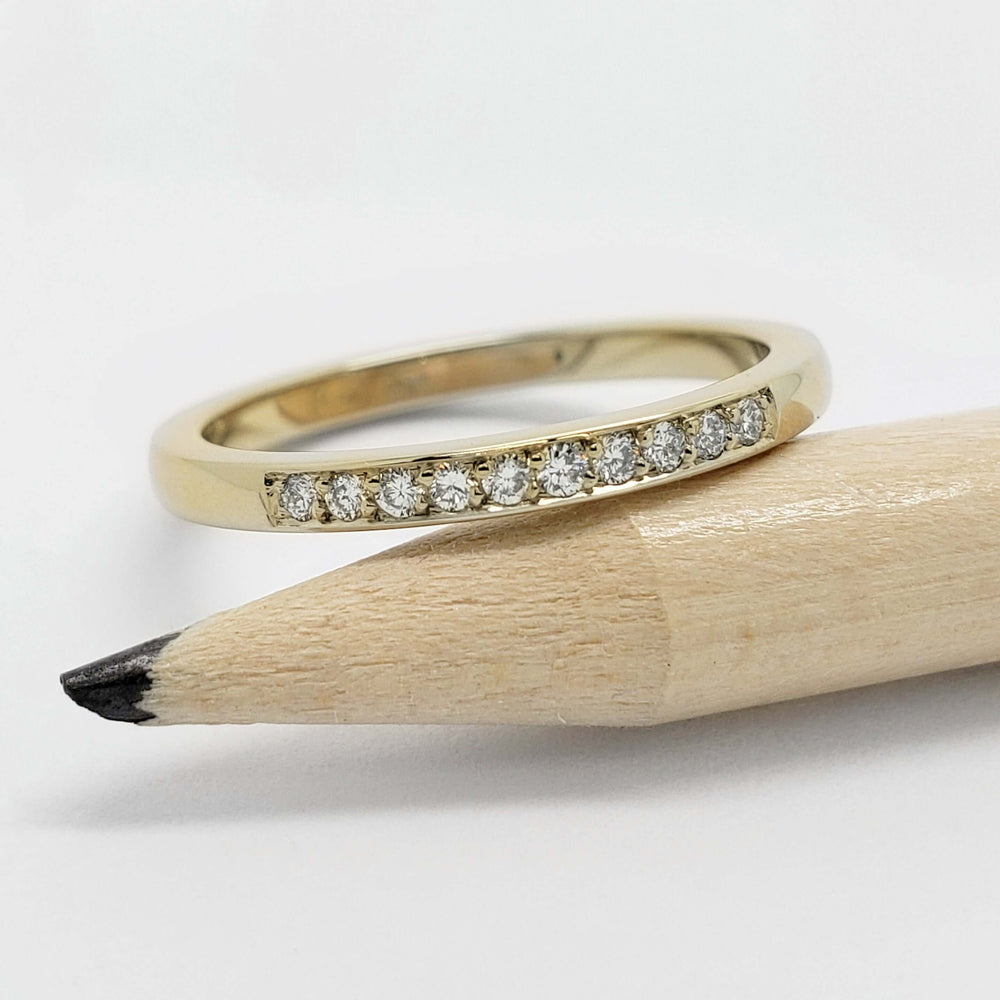14kt yellow gold lab diamond wedding ring shown next to a pencil for scale