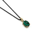 14kt yellow gold pendant with oval cabochon lab emerald on a black chain, angled view