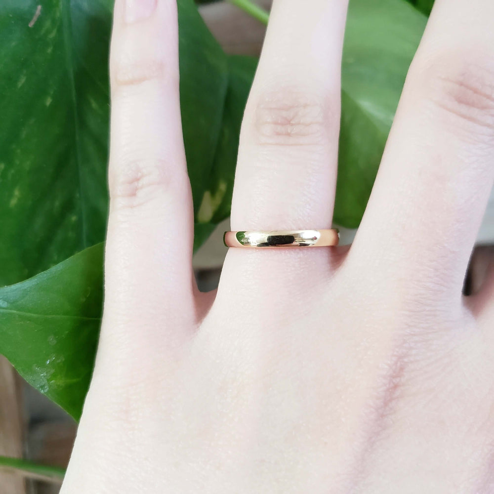 14kt yellow gold low dome wedding ring shown on a hand