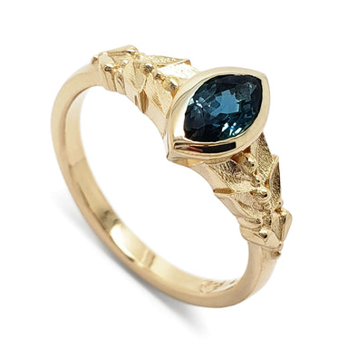 14kt yellow gold ring with marquise blue Montana sapphire and leafy textured band