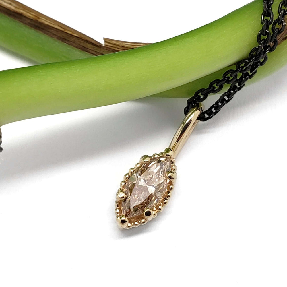 14kt yellow gold marquise champagne diamond pendant displayed on a green stem