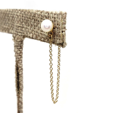 Single 14kt yellow gold pearl stud earring with chain dangle on display stand